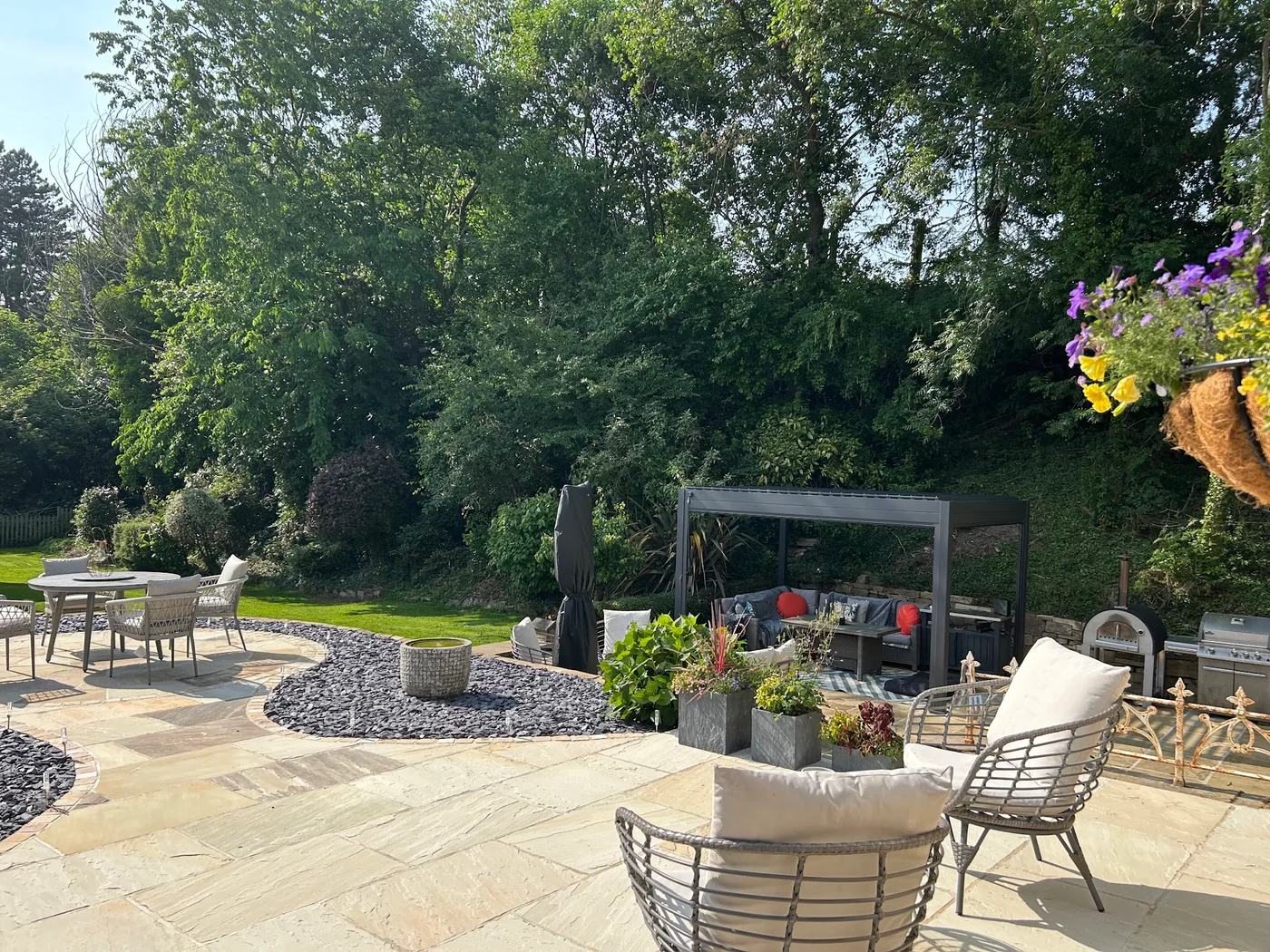 Finished curved stone patio with outdoor seating and a garden path